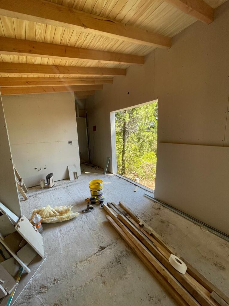 Obra en proceso de Flor de Casa en Bariloche: interior con placas colocadas y techo de madera a la vista