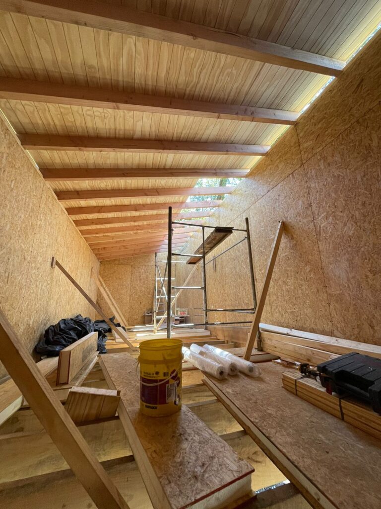 Obra en proceso de Flor de Casa en Bariloche: interior con paredes de paneles SIP y estructura de techo de madera
